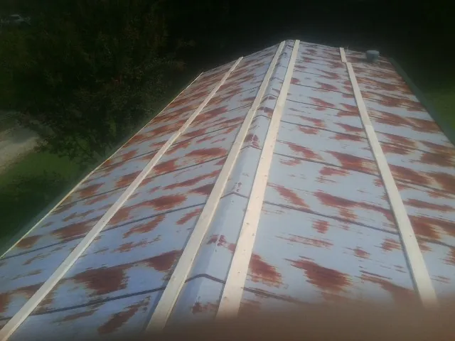 Rusted metal roof panels with new wood purlins before replacement — Storm Damage Roof Repair in Marine by Roofing Brothers