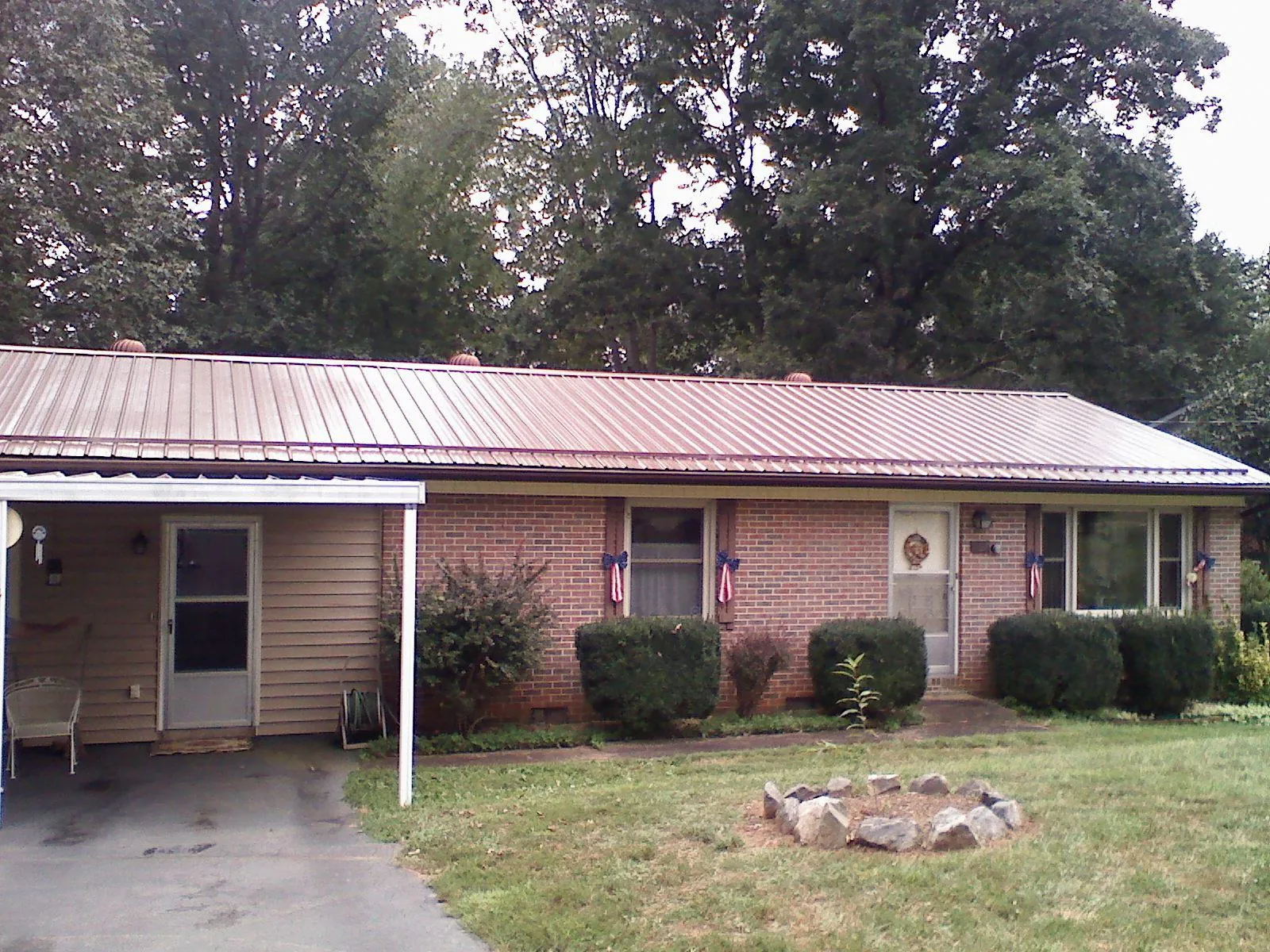 Bronze metal roof and carport on a brick ranch home — Roof Repair work by our crew in Marine
